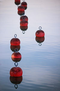 Red lanterns hanging over lake against sky