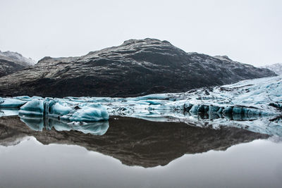 Scenic view of iceland glacier against mountain and sky during winter