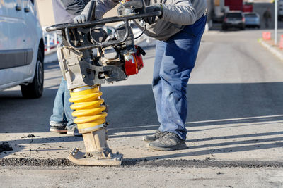 Low section of man working on street in city