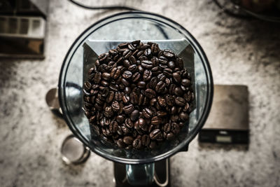 Directly above shot of roasted coffee beans in mill on table