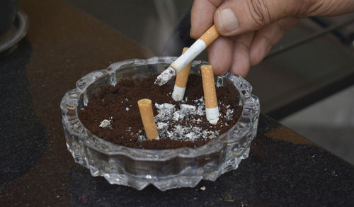 Close-up of hand holding cigarette