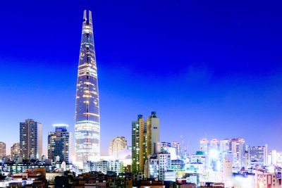 Modern buildings against blue sky at night