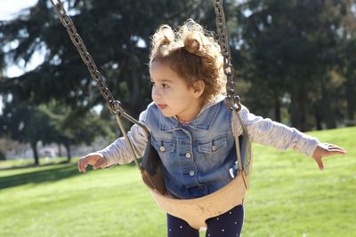 Close-up of girl on swing at playground