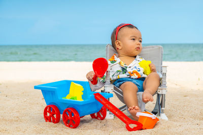 Cute boy sitting on beach