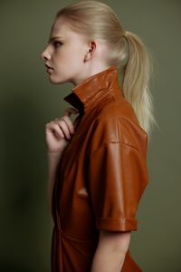 Young woman standing against black background