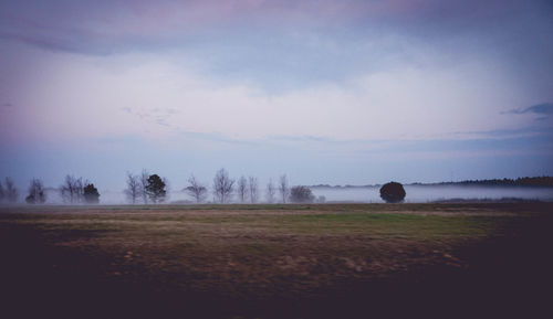 Scenic view of field against cloudy sky