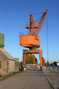 Crane at construction site against clear blue sky