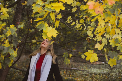 Woman standing on yellow leaves