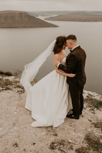 Rear view of couple standing at beach