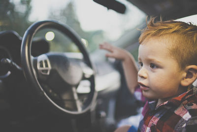 Close-up of boy looking away while sitting in car