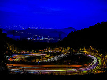 High angle view of light trails on road against sky at night