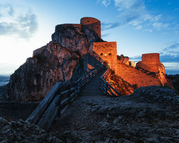 Low angle view of fortress on rock against sky