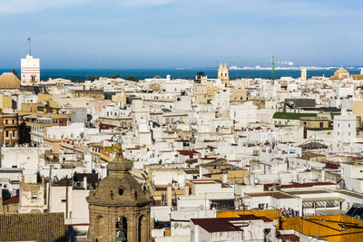 High angle view of townscape by sea against sky