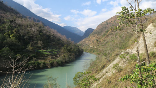 Scenic view of river amidst mountains against sky