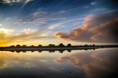 Scenic view of lake against sky at sunset
