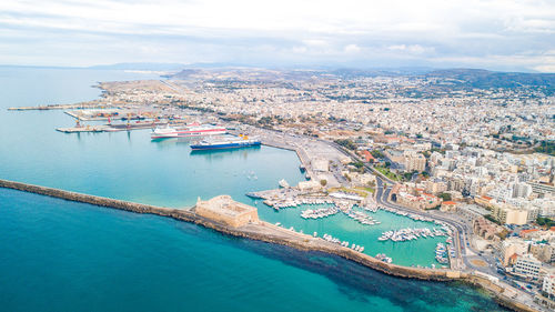 High angle view of sea by buildings against sky