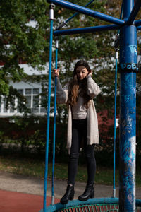 Young woman standing on outdoor play equipment