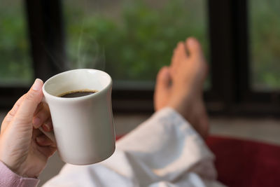 Close-up of hand holding coffee cup