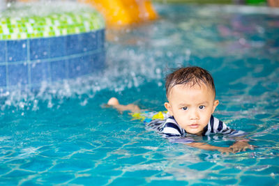 Portrait of boy swimming in pool