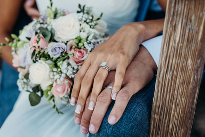 Midsection of newlywed couple holding hands in wedding ceremony