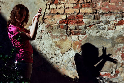 Full length of man with text on brick wall