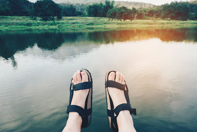 Low section of person relaxing over lake