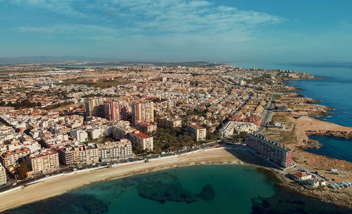 High angle view of sea and buildings against sky