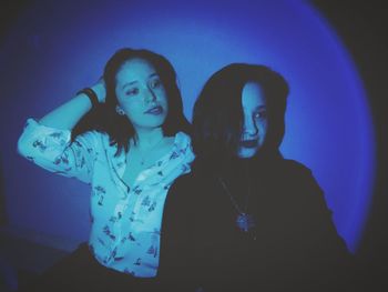 Young woman looking away against black background