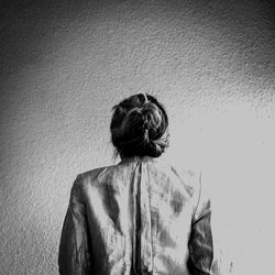 Rear view of woman standing against wall