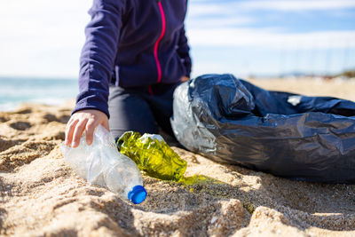 Little kid picking plastic on the beach. recycling concept