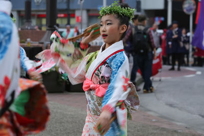 Young woman with umbrella walking on road