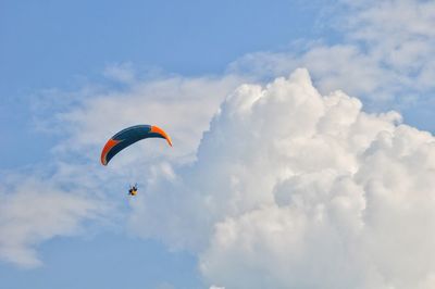 Low angle view of person paragliding against sky