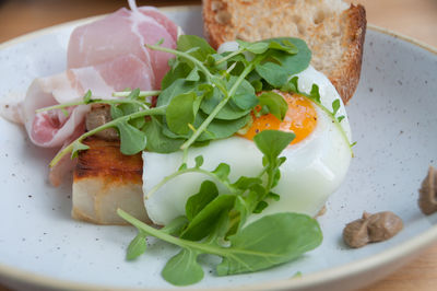 Breakfast of egg with runny yolk on sourdough toast with bacon, pancetta. breakfast meal close up