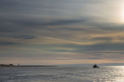 Boat sailing in sea against sky during sunset