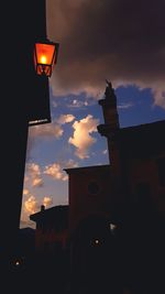 Low angle view of illuminated building against sky at sunset