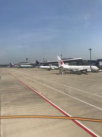 Airplane on airport runway against sky