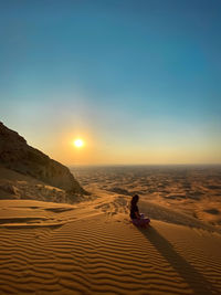 Women watching sunset in the desert 