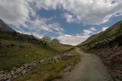 Road leading towards mountains against sky