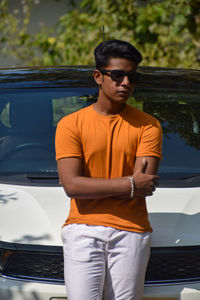 Portrait of young man standing in car