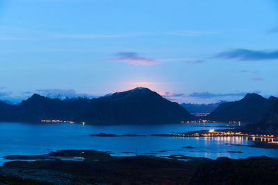 Scenic view of sea and mountains against sky at sunset