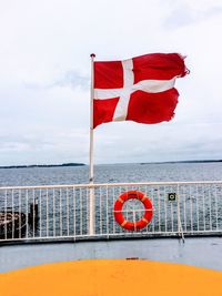 Red flag on railing against sea