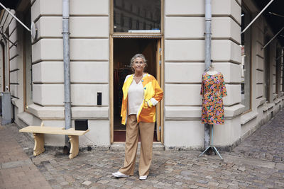 Portrait of female owner with disability standing in front of store