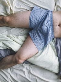 High angle view of man lying on bed