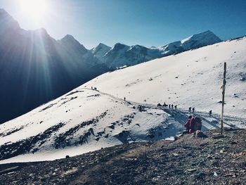 Scenic view of snowcapped mountains against sky during sunny day