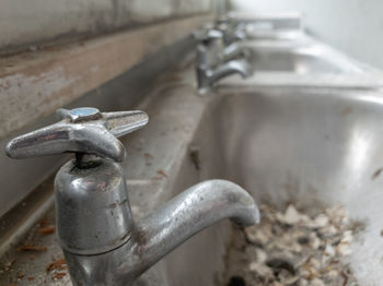 Close-up of old faucet in bathroom