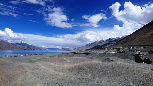Scenic view of sea and mountains against blue sky