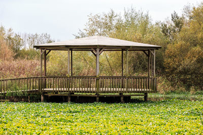 Park bench on field against sky