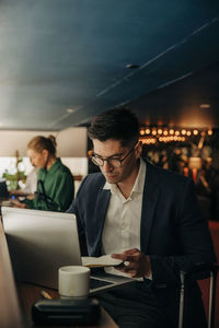 Serious businessman working on laptop in hotel lounge