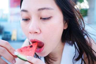 Close-up of woman eating watermelon slice