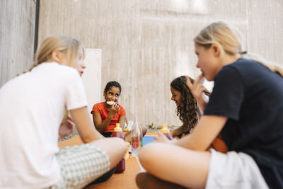 Female friends eating food at sports court